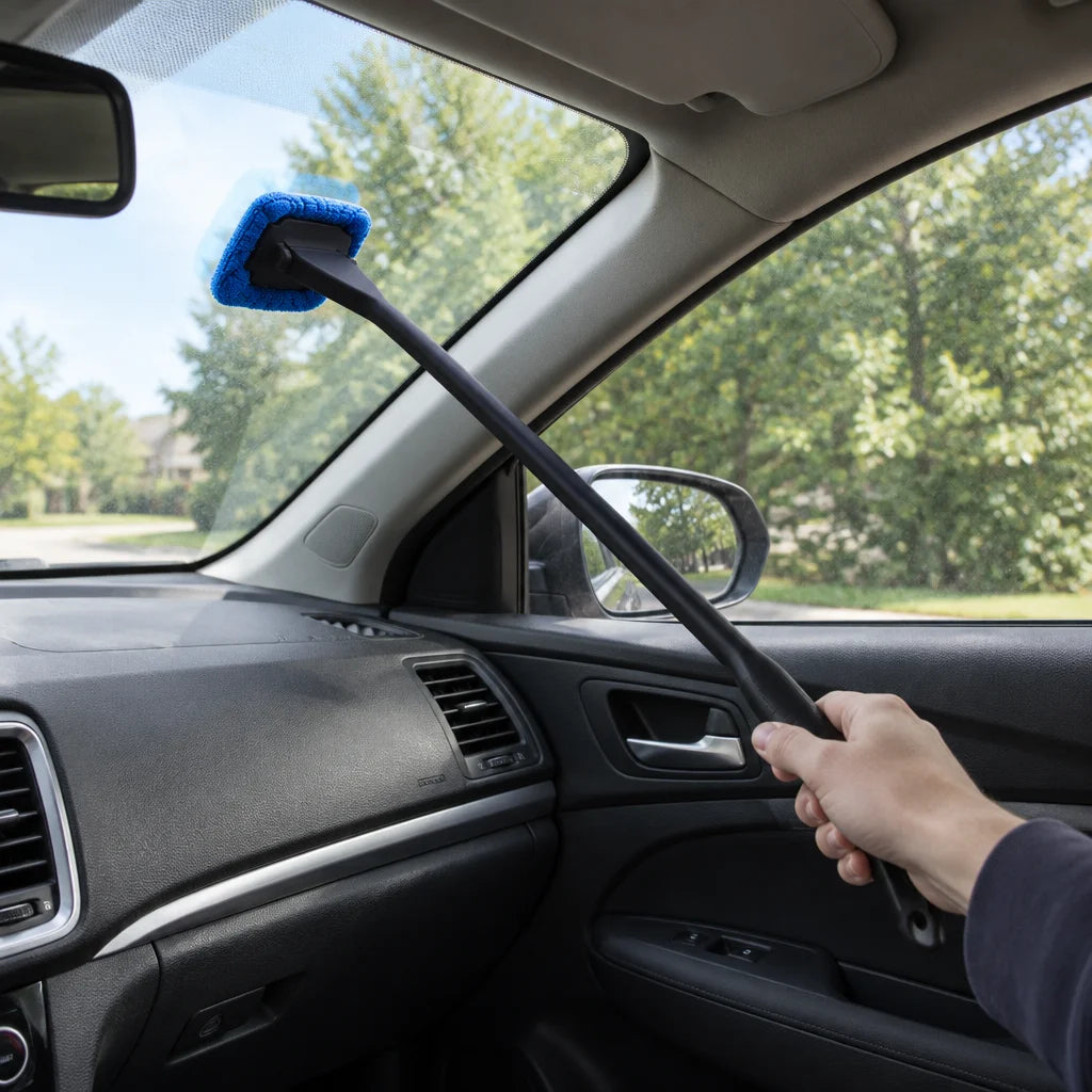 Show this exact interior windshield cleaning tool used from the passenger side of a real vehicle to