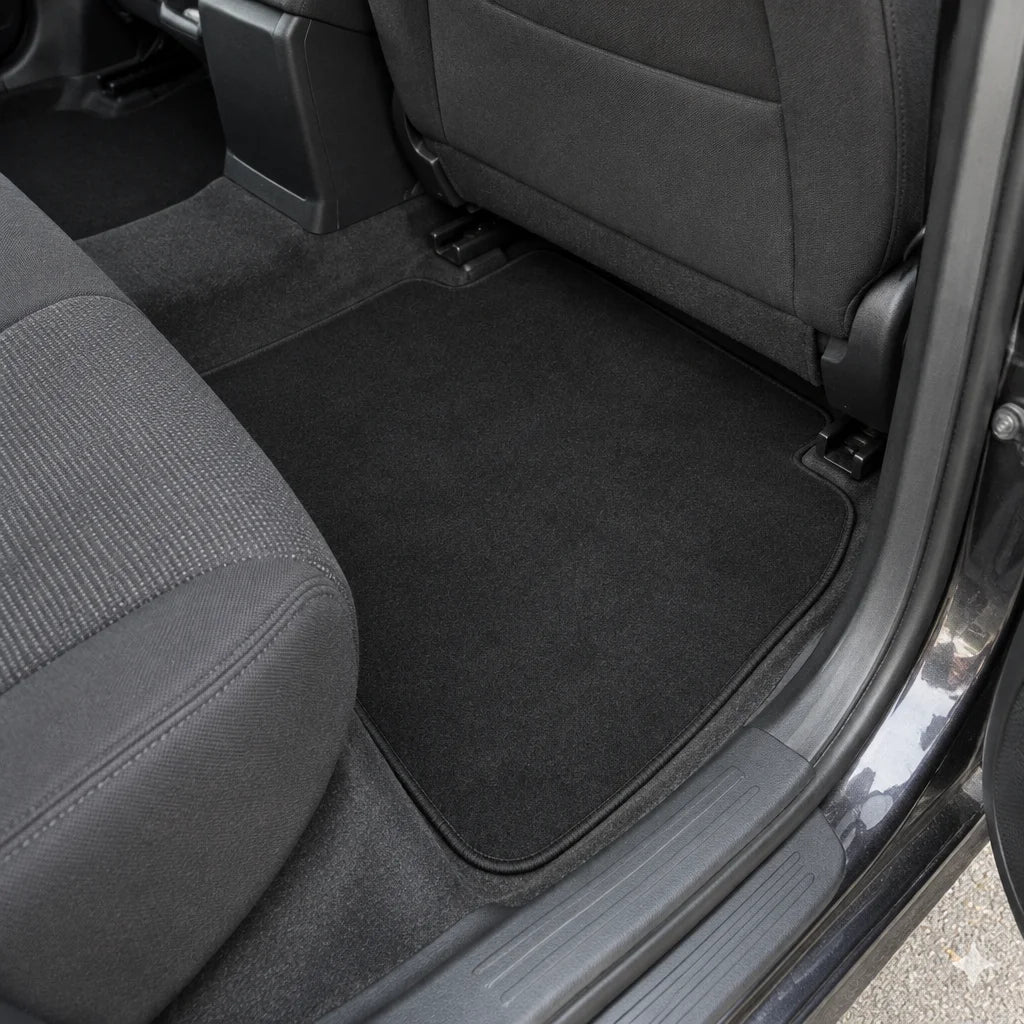 Show these exact universal car floor mats in the rear footwell of a real vehicle, with the available