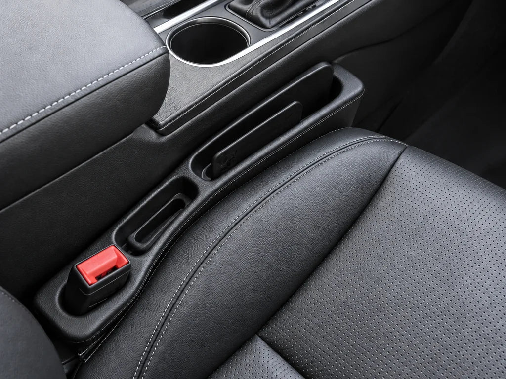 Show a close detail of this exact organizer in the seat gap, with the vehicle seat, console, and ava