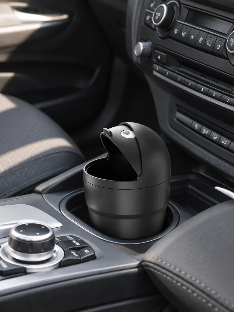 Show this exact compact covered car trash can placed in a suitable cup holder or bottle holder insid