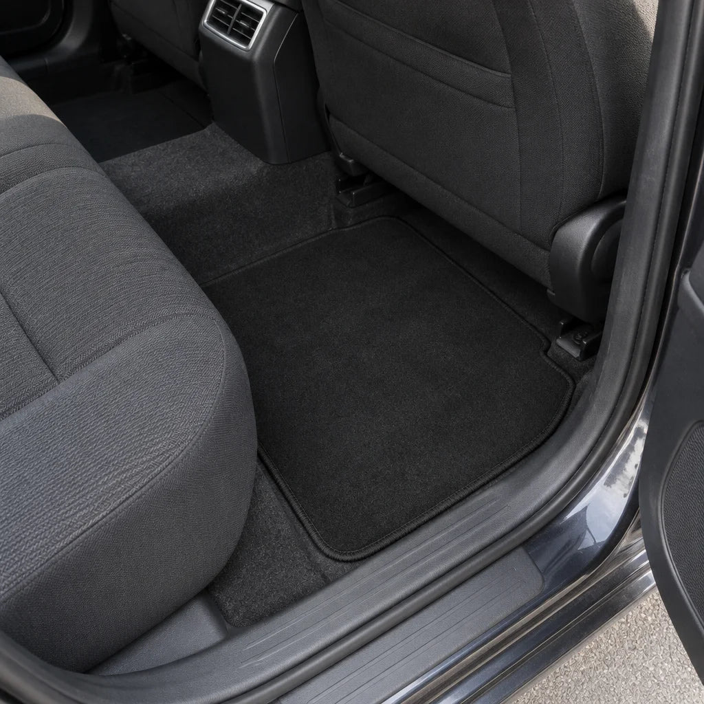 Show these exact universal carpet car floor mats in the rear footwell of a real vehicle, clearly sho
