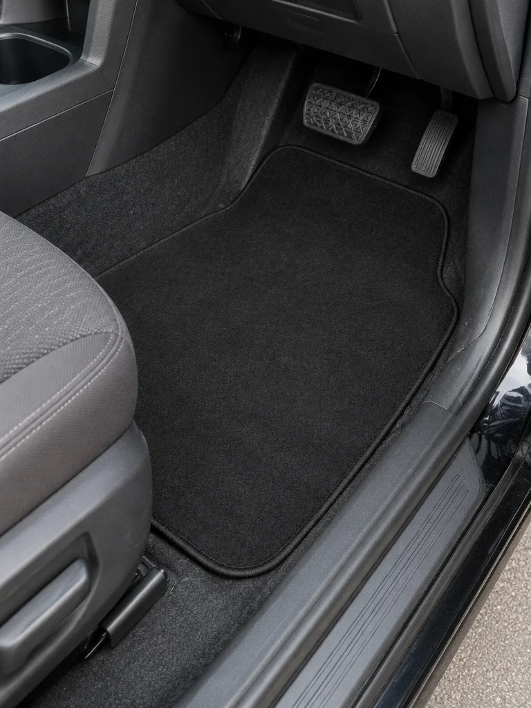 Show these exact universal carpet car floor mats installed in a real vehicle’s front footwell, with