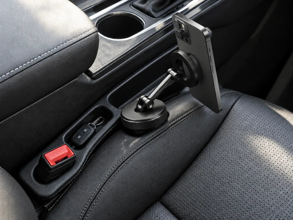 Show a close detail of this exact magnetic phone holder attached in the vehicle, including the phone