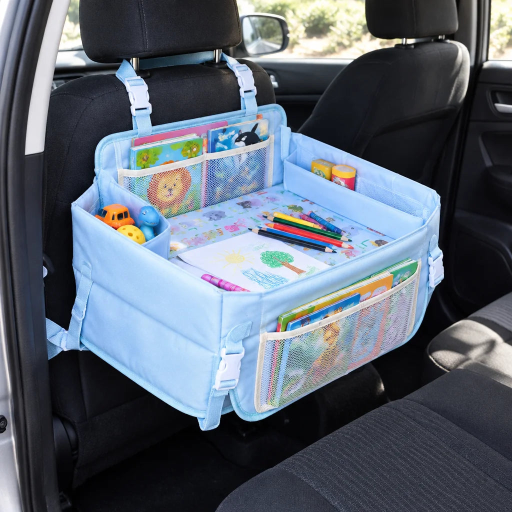 Show this exact foldable travel tray open in a real vehicle with books, toys, and drawing materials